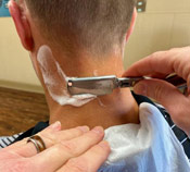 Barber shaving neck in Uica Michigan barbershop